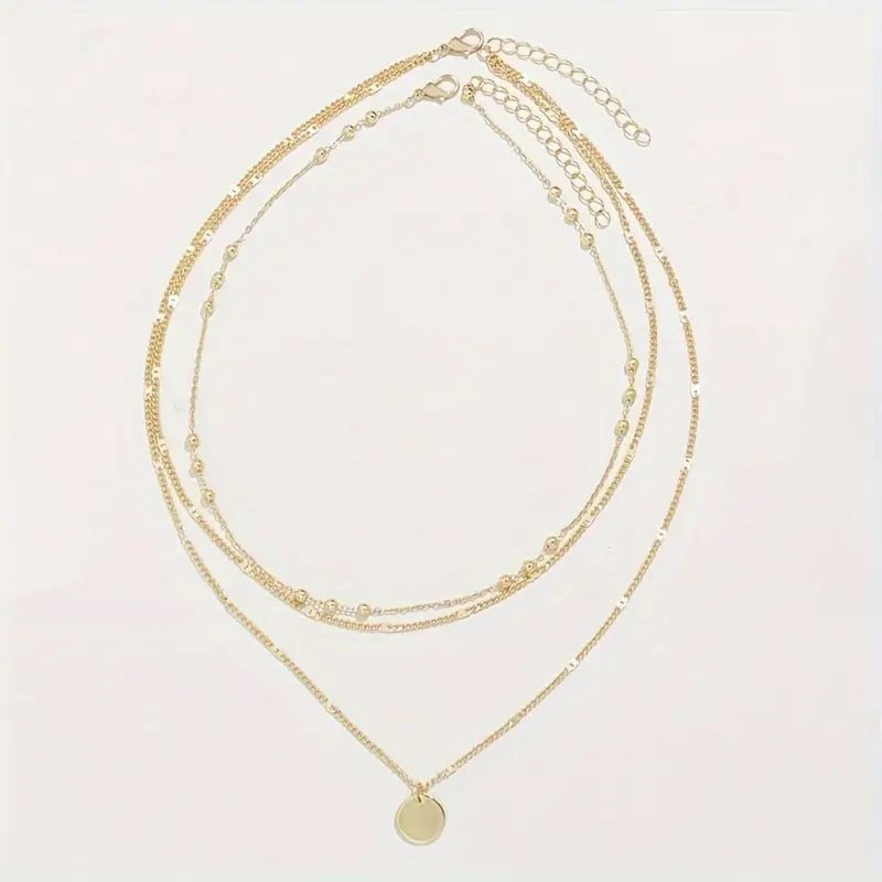 Erleben Sie schlichte Raffinesse mit unserem „Chic Tiers“-Anhänger-Set. Dieses dreilagige Kettenensemble aus hochwertigen, vergoldeten Eisenketten besticht durch seinen luxuriösen Glanz und seine dauerhafte Wasserfestigkeit – ideal für den täglichen Gebrauch und auf Reisen. Der mehrsträngige Scheibenanhänger setzt einen modernen, edlen Akzent, während das klare, elegante Design in strahlendem Gold eine zeitlose Ausstrahlung vermittelt. „Chic Tiers“ ist vielseitig kombinierbar.