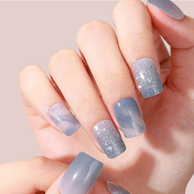 Cosmic Grey verleiht Ihren Nägeln einen mystischen Touch mit einem galaktischen Grau, das durch tiefblaue Nuancen intensiviert wird. Diese innovative Farbe kombiniert zeitgemäße Eleganz mit einem Hauch futuristischen Flairs und setzt modische Akzente, die Ihren Look veredeln. Ideal für trendbewusste Frauen, die einen modernen, kosmischen Stil anstreben, bringt Cosmic Grey einen unverwechselbaren, avantgardistischen Touch in jede Maniküre.